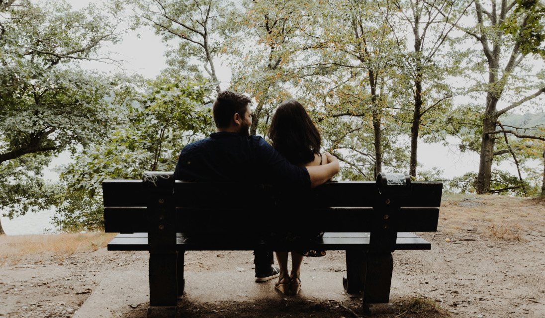 Two partners sitting together on a park bench